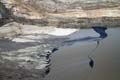 the_surface_chemicals_are_skimmed_across_the_surface_using_floating_lines_like_those_used_in_oil_spills